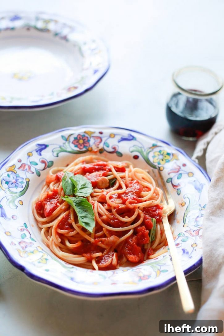 An elegant Italian pottery bowl filled with perfectly cooked spaghetti, generously coated in vibrant pomodoro sauce and garnished with fresh basil leaves, ready to be enjoyed.