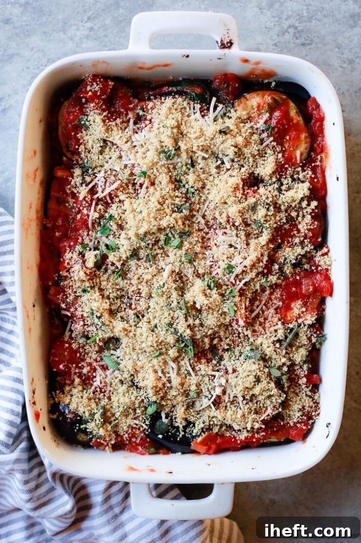 Healthy vegan baked eggplant parmesan casserole topped with breadcrumbs and oregano is ready for the oven. 