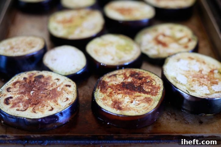 Browned eggplant slices on a griddle are the start of baked eggplant parmesan. 