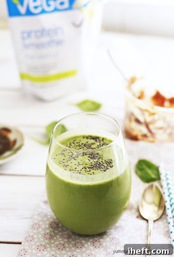 Green spinach smoothie in a glass topped with chia seeds.