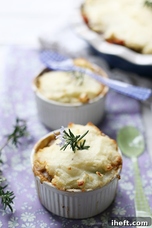 A miniature lentil shepherd's pie, brimming with a savory vegetarian and vegan filling and topped with creamy mashed potatoes, served in a small ramekin for a comforting dinner.