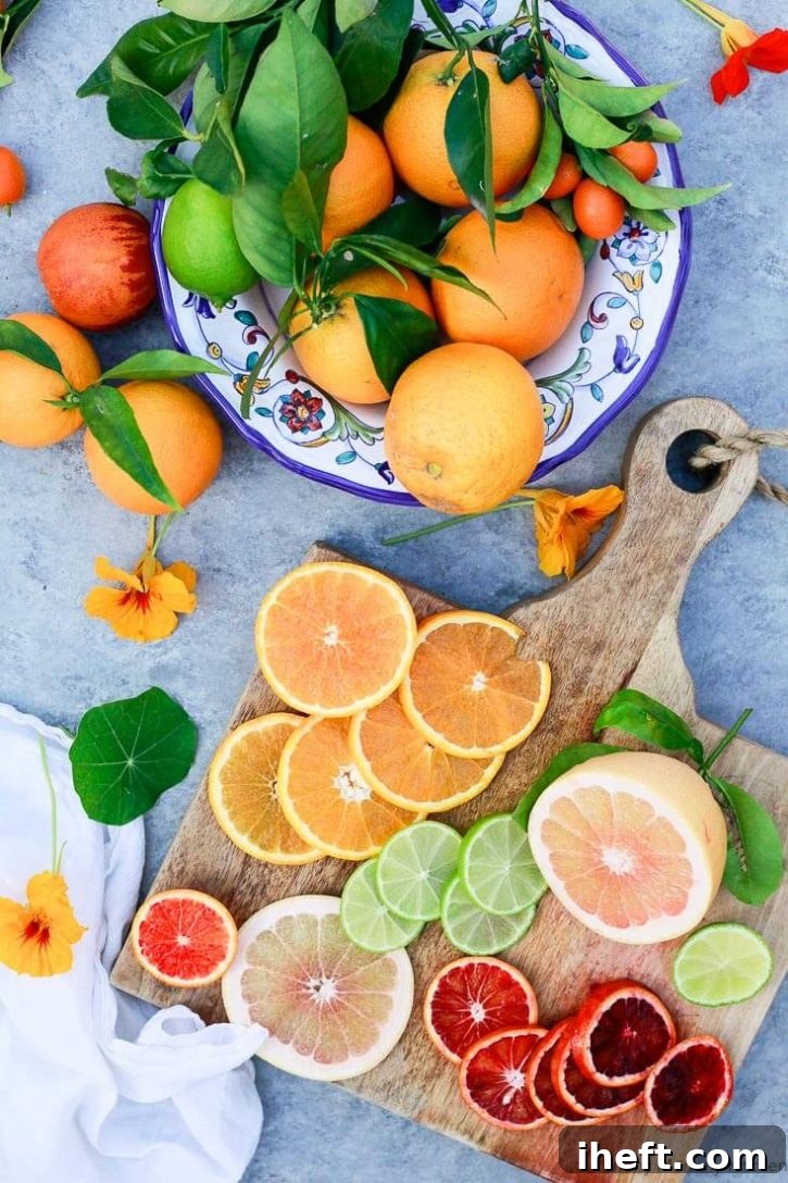 A bowl of oranges next to sliced blood oranges, grapefruit, and limes, all prepared for making Aperol Spritz cocktails.