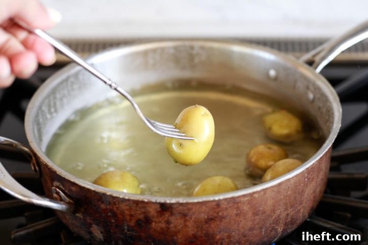 Small yellow potatoes boil in a large copper pot. 