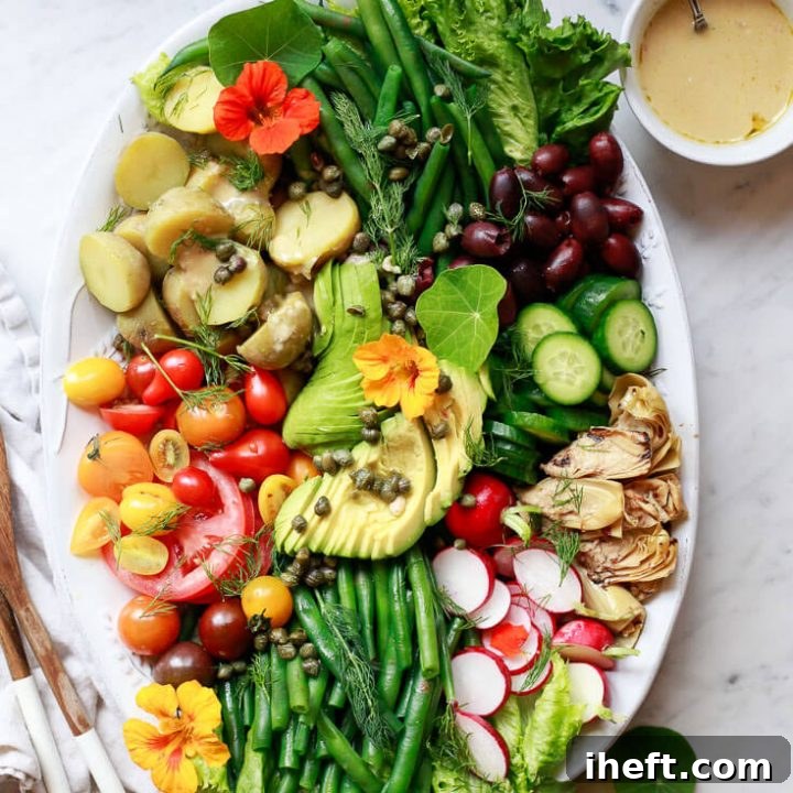 Beautiful Nicoise salad platter with green beans, tomato, and avocado. A vegan spring salad recipe.