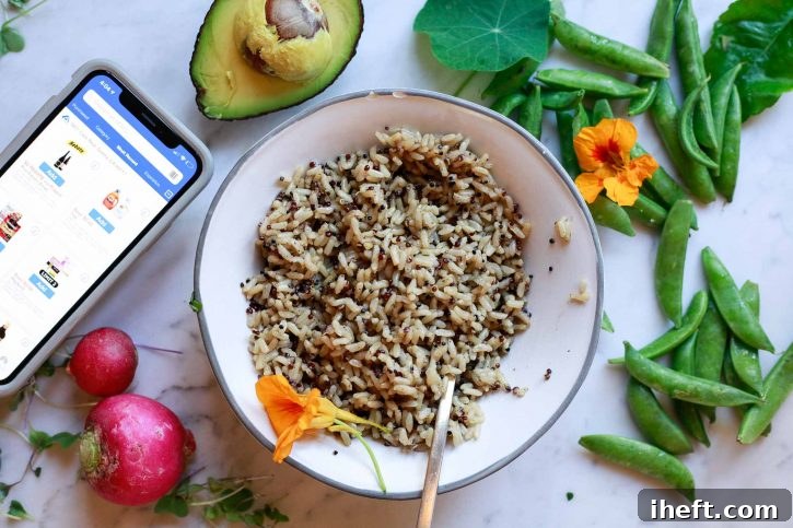 A steaming bowl of perfectly cooked Seeds of Change Brown Rice and Quinoa with Garlic, sitting invitingly on a clean countertop, surrounded by a colorful array of fresh, uncooked vegetables, awaiting its transformation into a delicious grain bowl.