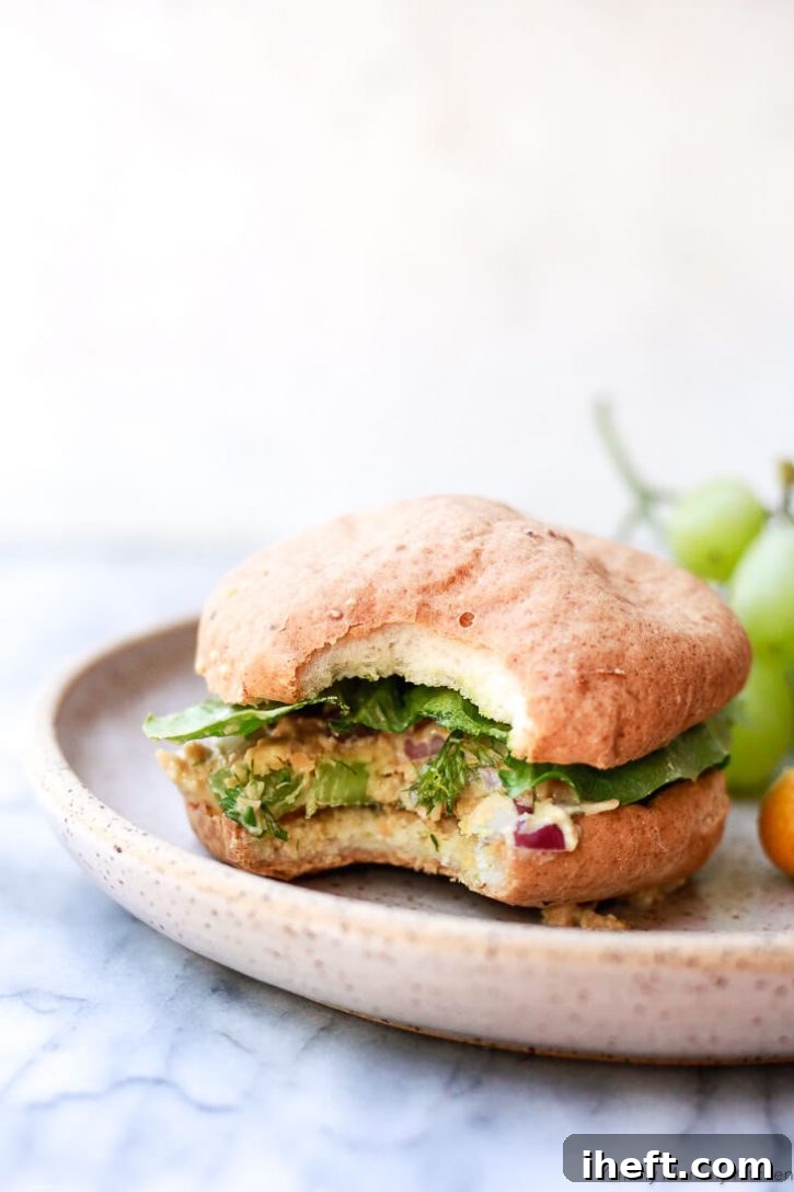 A delicious chickpea salad (vegan chicken salad) on a hamburger bun with lettuce. 