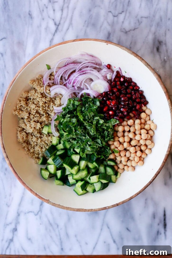 A beautiful salad with chickpeas, quinoa, herbs, cucumber, onion, and pomegranate. 