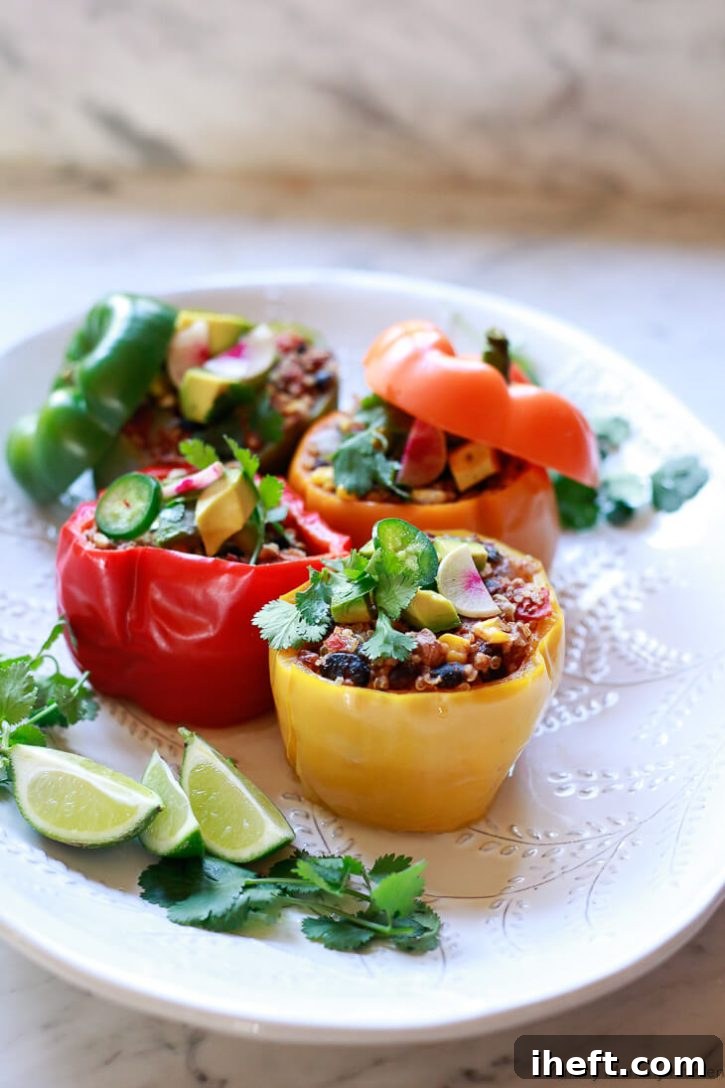 Beautiful and delicious vegetarian stuffed bell peppers with quinoa, corn, and black beans sit on a white platter. These healthy vegan quinoa stuffed peppers have a Southwest Mexican spin and are easy to make in the Instant Pot. 