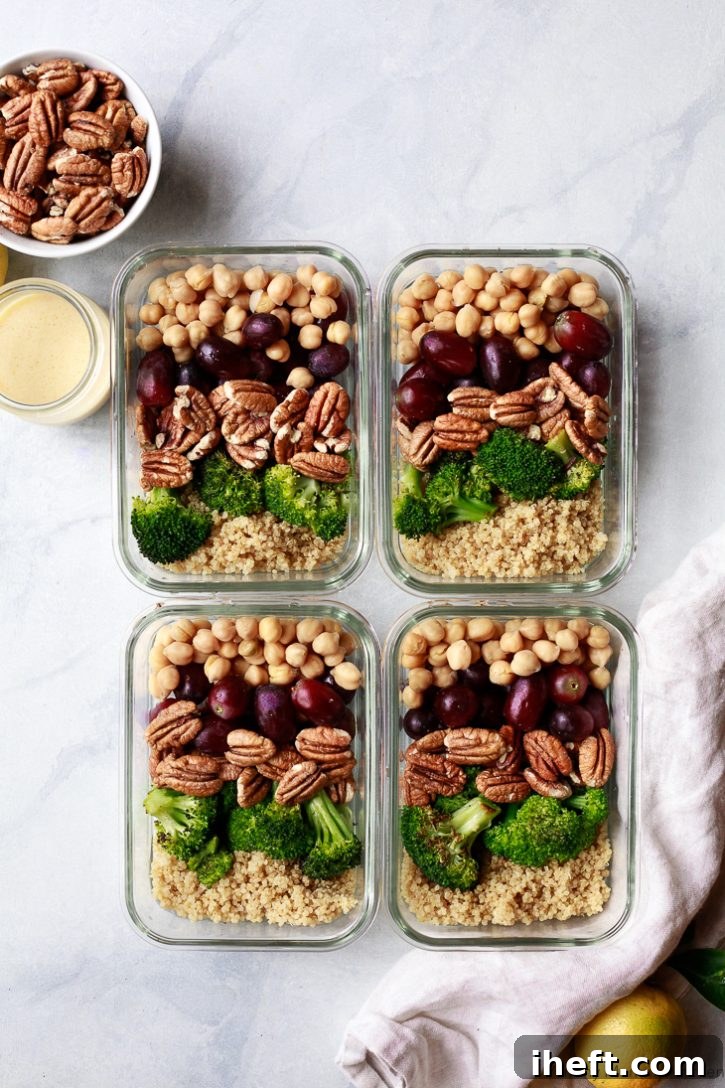 Four pristine glass meal prep containers, each perfectly filled with a balanced and healthy vegan meal of quinoa, roasted broccoli, juicy grapes, crunchy pecans, and protein-rich chickpeas, neatly arranged on a kitchen counter. A perfect visual representation of delicious healthy vegan meal prep.