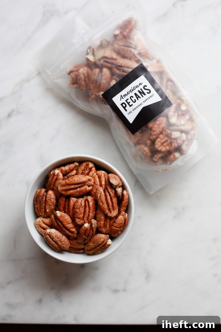 A bag of American Pecans resting on a white marble countertop, with a small bowl filled with pecan halves beside it, showcasing their natural beauty.