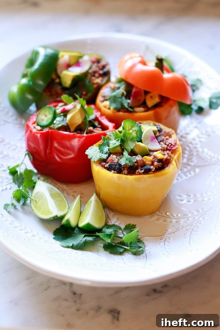 Colorful quinoa and black bean stuffed bell peppers with pecans, served as a beautiful, healthy vegan dinner.