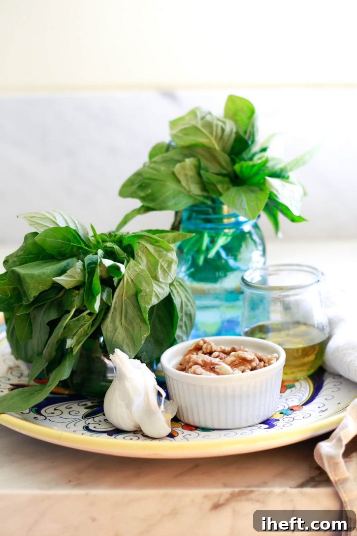 Jars of fresh basil, garlic, walnuts, and olive oil on an Italian pottery dish on a kitchen counter. 