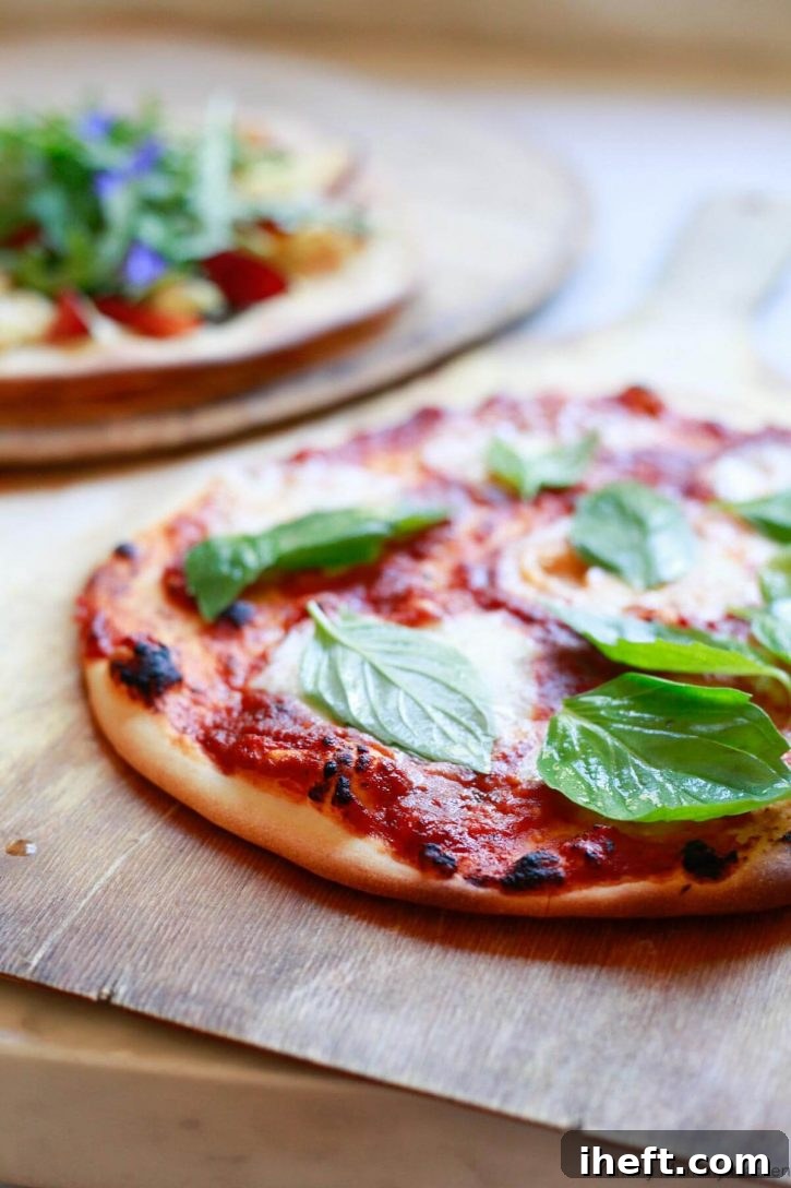 Homemade pizza with fresh basil on a pizza peel.