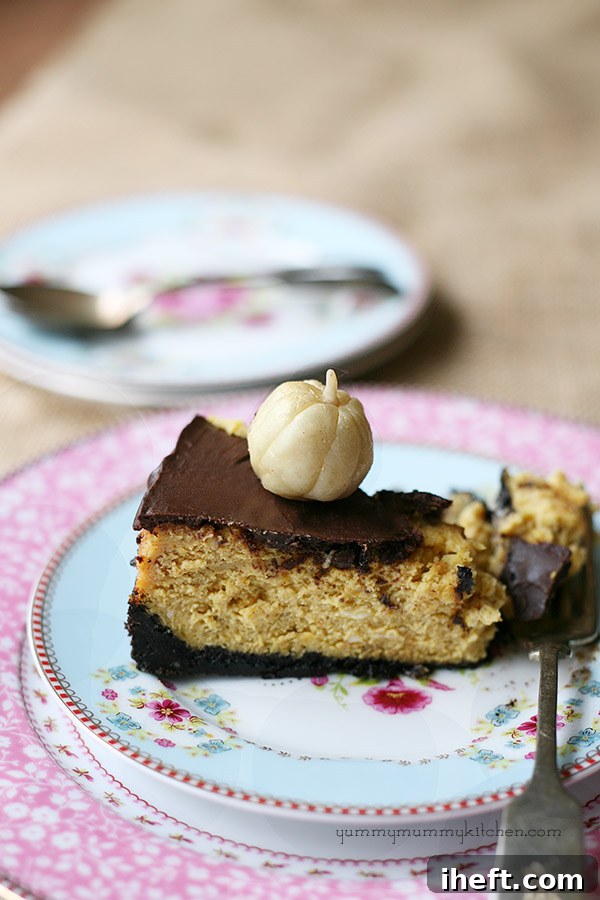 A slice of creamy Pumpkin Cheesecake with Chocolate Ganache and an Oreo crust