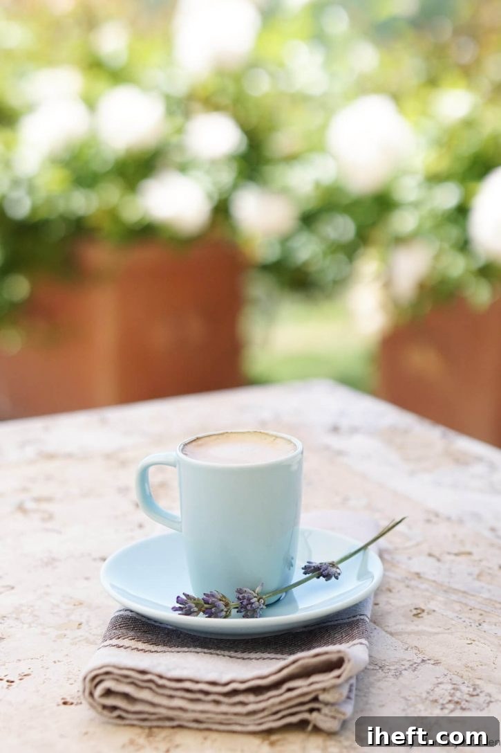 A small, elegant blue espresso cup containing a freshly brewed shot of espresso, complete with its matching saucer, rests on a rustic outdoor table in the picturesque region of Tuscany, Italy, evoking a sense of calm and authenticity.