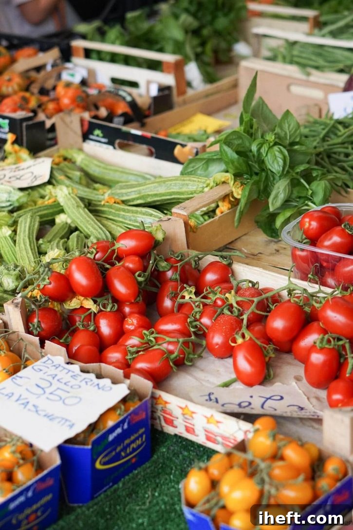 Tomatoes, basil, and zucchini for sale at a farmer's market in Tuscany. 