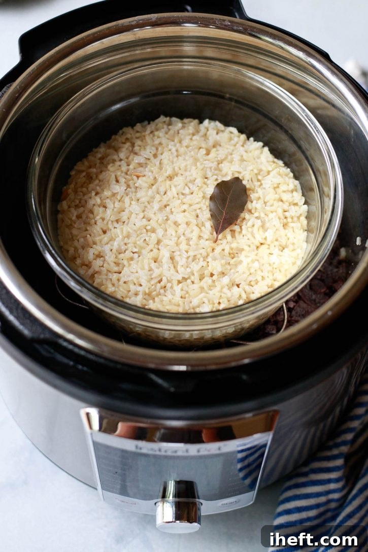 Brown rice and black beans cooked together in the Instant Pot with the pot in pot method. The rice sits on a trivet above the beans. 