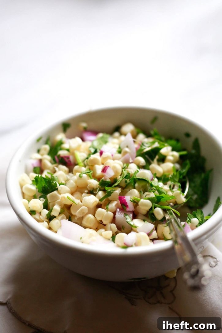 A small white bowl of fresh corn salsa inspired by Chipotle's recipe. 