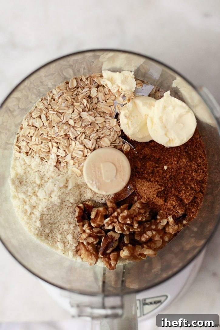 Oats, almond flour, nuts, butter, and coconut sugar in a bowl to make a gluten free fresh fruit crisp topping. 