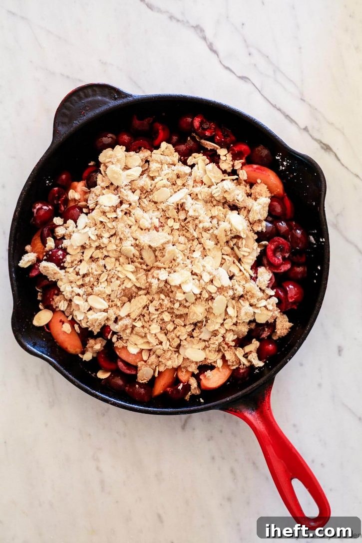 Fresh cherry crisp with gluten free almond topping in a red skillet before going into the oven. 
