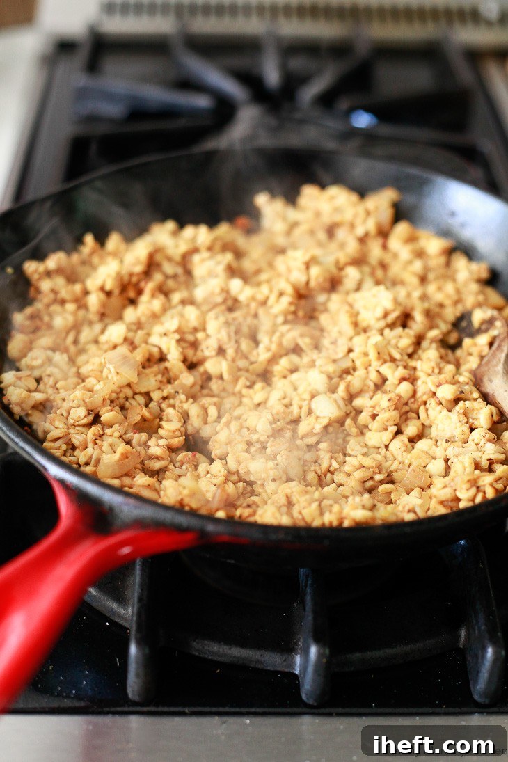 Crumbled tempeh taco meat simmers in a skillet.