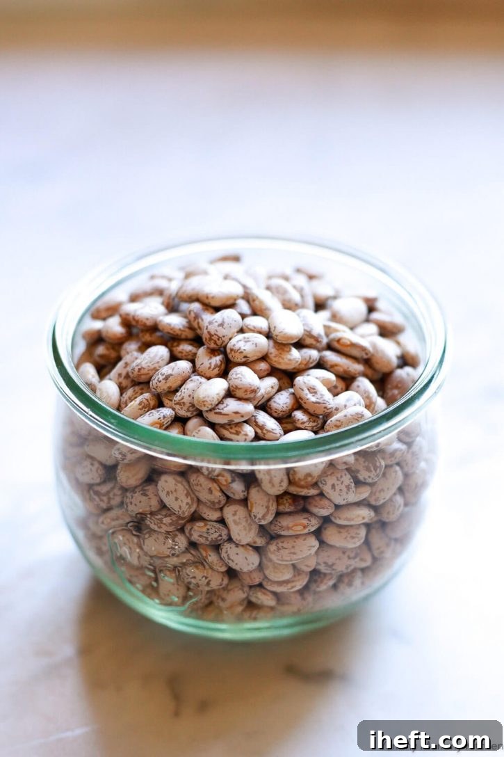 A glass jar filled with pinto beans. 