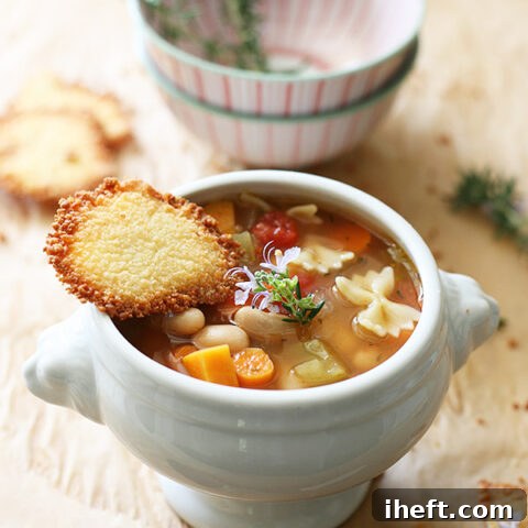 a bowl of pasta e fagioli soup with parmesan crisp.