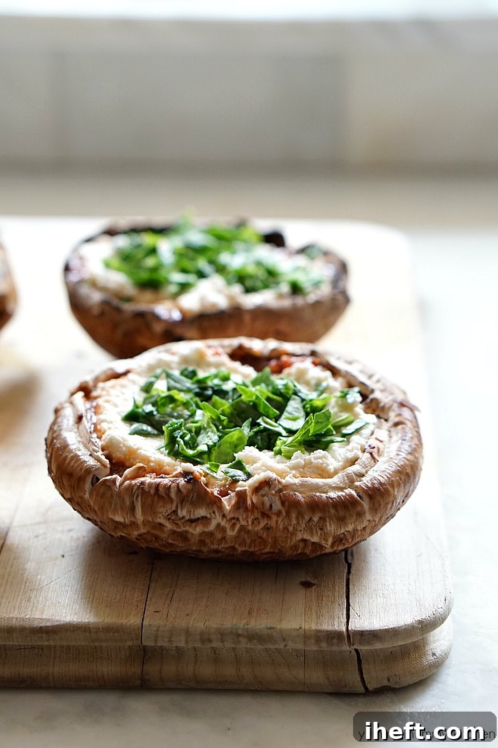 Portobello mushrooms stuffed with a spinach lasagna filling and ready to be baked in the oven.