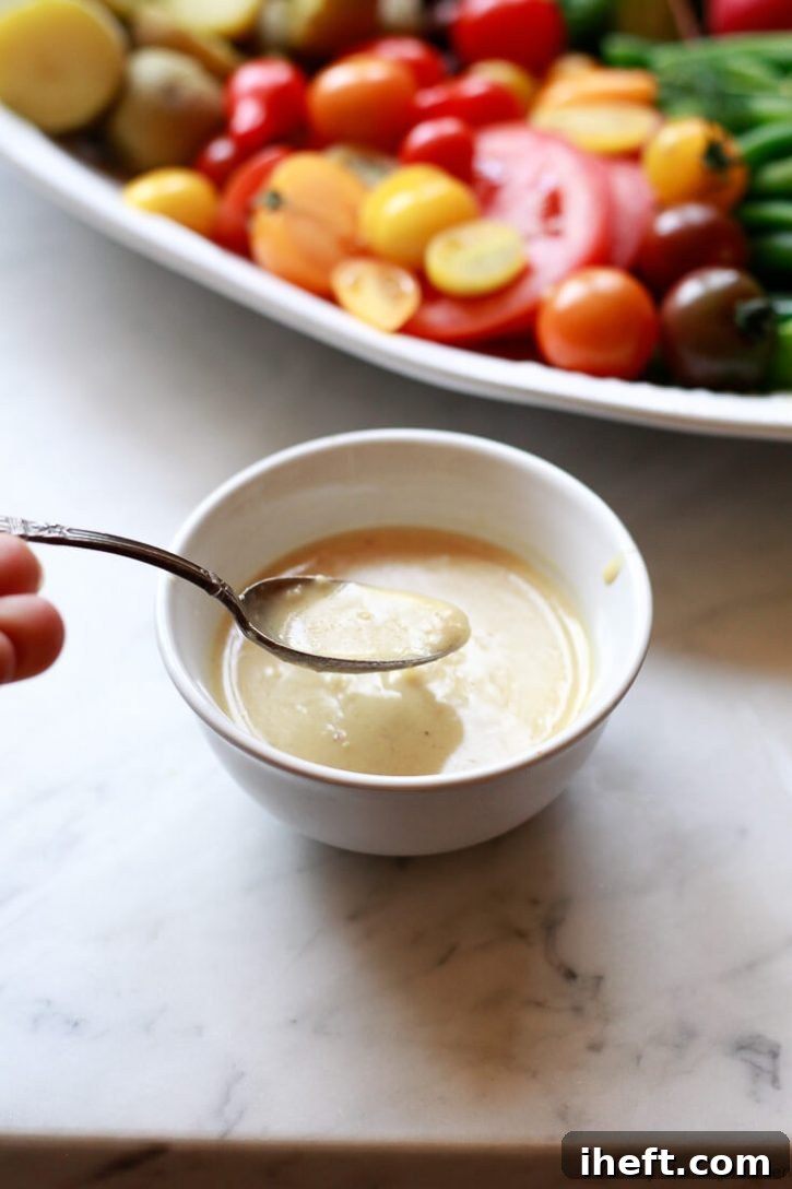 A close-up of creamy homemade shallot dressing, glistening and ready to be drizzled over a fresh salad.