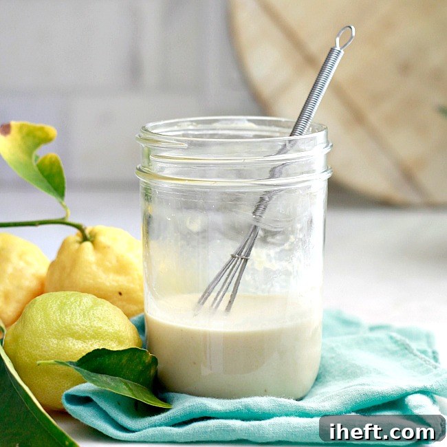 Creamy Lemon Tahini Salad Dressing drizzled over fresh greens in a bowl.