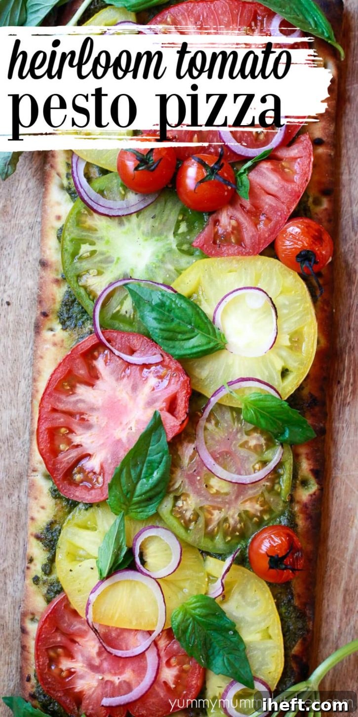 Beautiful cheeseless vegetarian & vegan pizza recipe topped with vibrant heirloom tomatoes, aromatic pesto, and fresh basil leaves. Ideal for summer meals with homemade or store-bought dough.