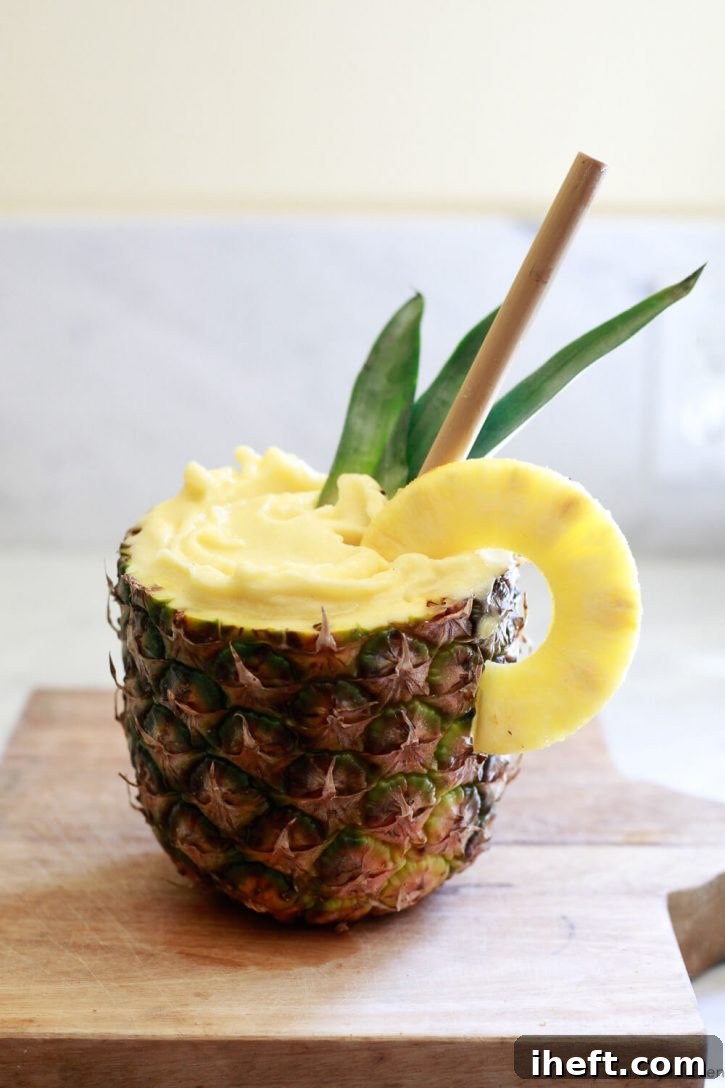 A tropical pineapple smoothie served elegantly in a hollowed-out pineapple, adorned with a bamboo straw and a garnish, evoking a serene island vibe.