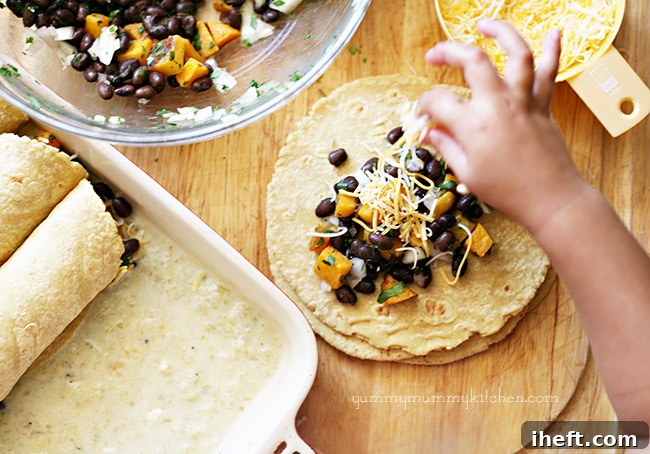 A child's hand helping spoon the butternut squash and black bean mixture onto a corn tortilla, a fun kitchen activity.