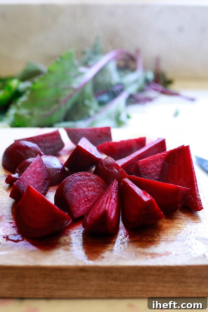Bright red cooked beets, beautifully peeled and cut into uniform wedges, with gentle steam rising, indicating they are freshly cooked and warm.