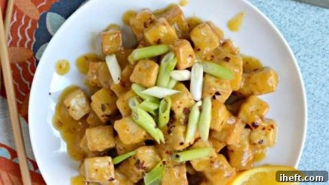 Golden crispy air fryer tofu coated in sticky orange sauce