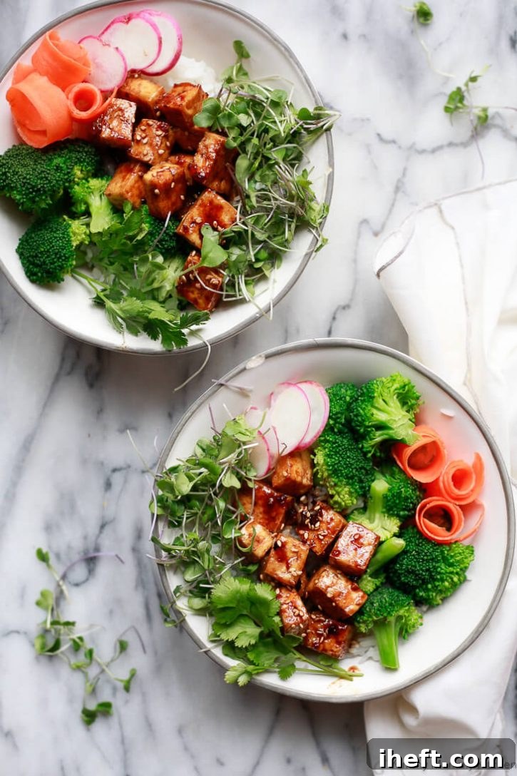 Tofu teriyaki bowls served with fluffy rice, steamed broccoli, fresh carrots, and delicate microgreens. A wholesome and delicious tofu recipe idea for dinner.