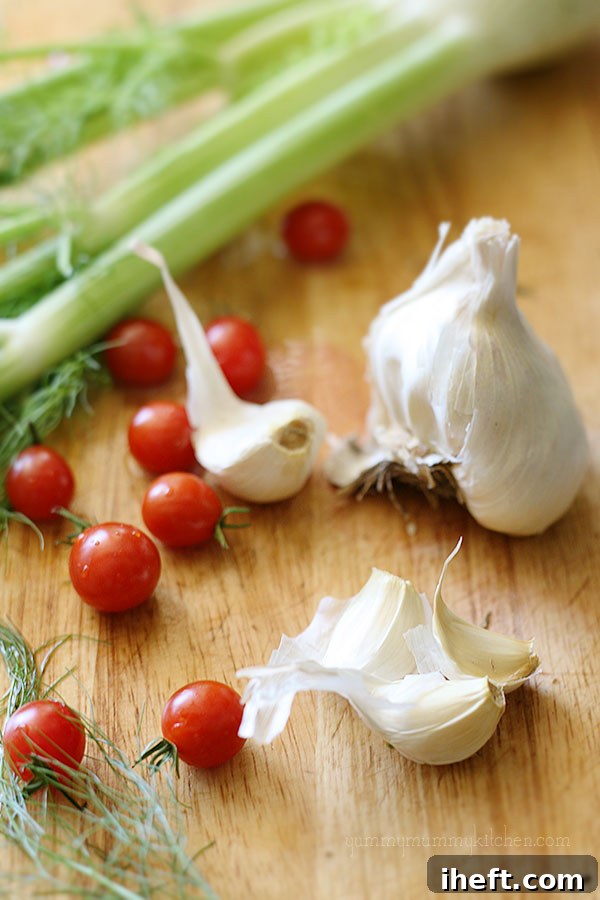 A selection of fresh ingredients including mussels, fennel, cherry tomatoes, and garlic, ready for cooking.