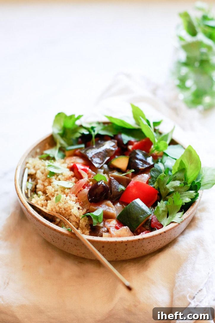 A hearty bowl of ratatouille served with fluffy quinoa and fragrant fresh basil, a perfect Instant Pot or slow cooker vegetarian meal.