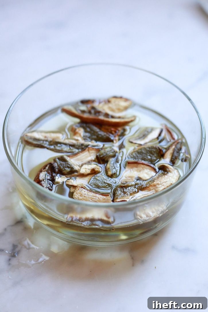 Dried Porcini mushrooms soaking in a bowl of warm water, rehydrating before use.