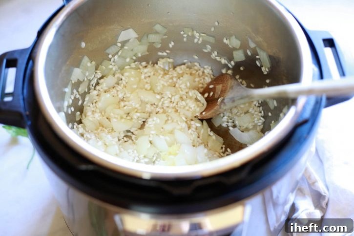 Minced garlic and Arborio rice being added to the Instant Pot after the onions have sautéed.