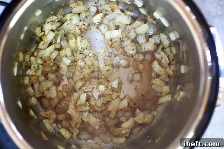 Onions, garlic, and spices saute in an Instant Pot to start making Instant Pot spaghetti sauce. 
