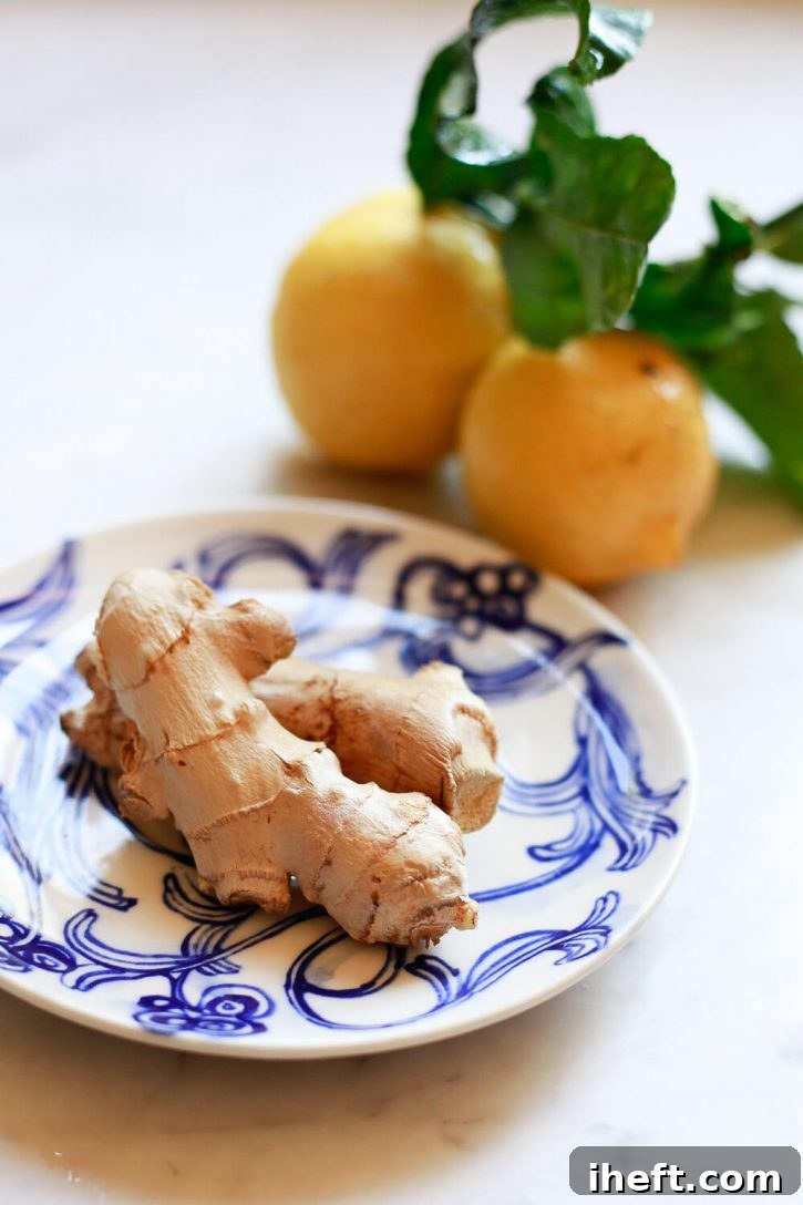 Fresh ginger on a small plate with lemons in the background. These are the ingredients for a ginger shot recipe. 