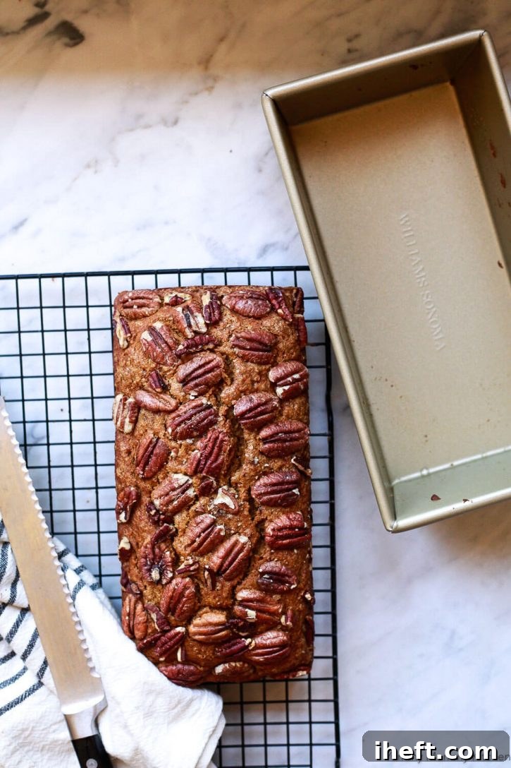 A loaf of healthy vegan whole wheat pumpkin bread on a cooling rack. 