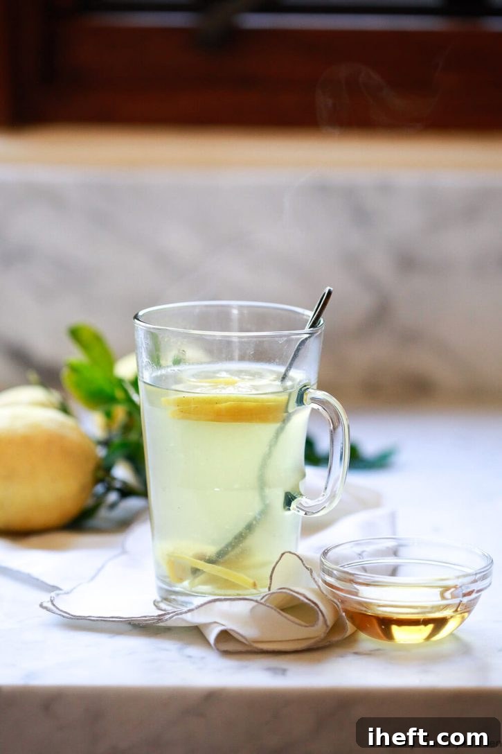 Steam comes off a cut of homemade detox tea with ginger and lemon. 