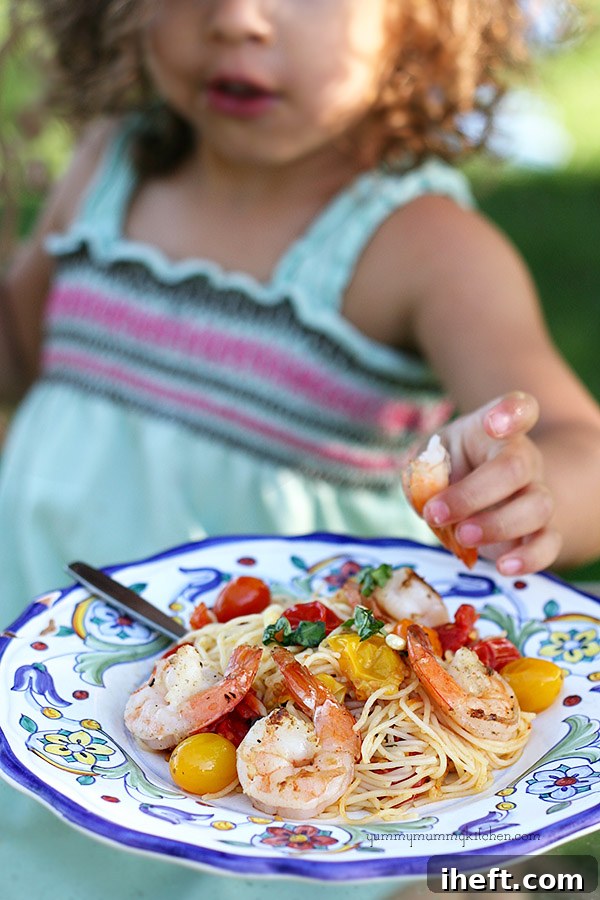 A serving of roasted tomato capellini topped with grilled shrimp and fresh basil, showcasing a personalized protein option.