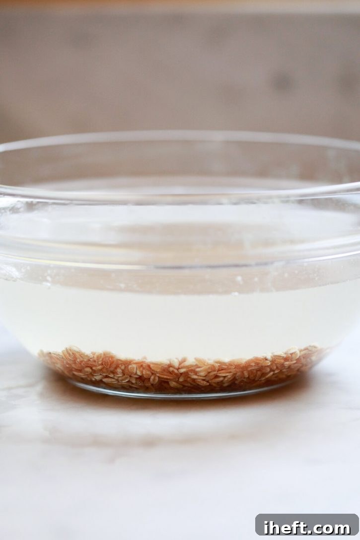 The initial step in cooking farro involves thoroughly rinsing it in a large bowl of water, ensuring cleanliness before preparation.