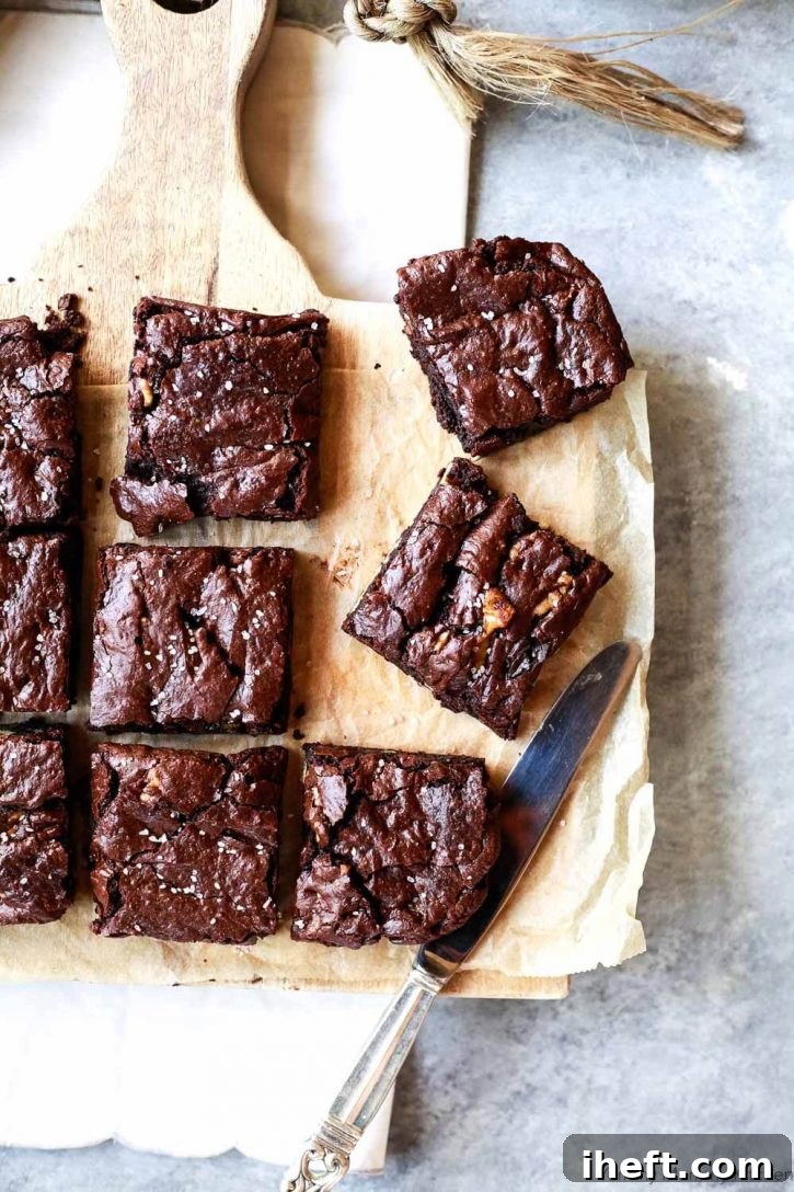 A pristine square of fudgy vegan brownie with a perfect crackly top, showcasing the ultimate dairy-free and eggless dessert. A truly irresistible treat.