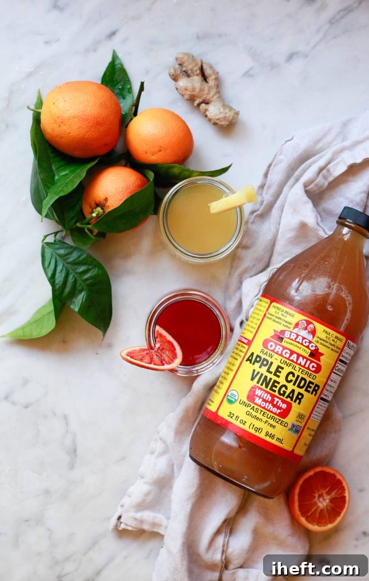 Two easy and tasty apple cider vinegar shots artfully presented, made with Bragg's ACV (with the mother) and fresh juice, ideal for daily detox support, immune system boosting, and overall wellness goals.