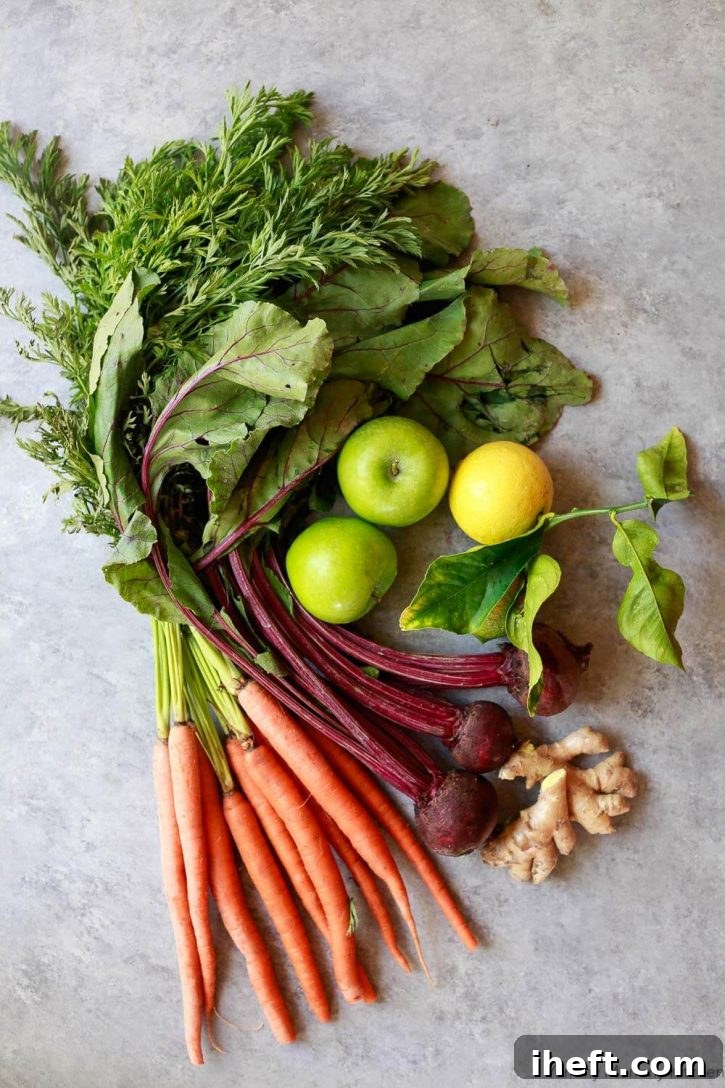 A vibrant assortment of healthy detoxifying ingredients laid out, including fresh carrots, deep red beets, pungent ginger root, bright yellow lemons, and crisp green apples, all ready to be transformed into refreshing and nutrient-dense detox beverages.