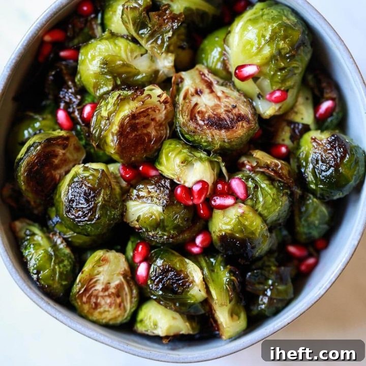 Roasted Brussels Sprouts garnished with pomegranate arils in a bowl.